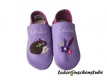 Lederpuschen lila-flieder, Namen beiderseits Spann weiß, Indianer Igel (Igel creme-braun-schwarz-altrosa) Blume (dunkellila-creme) Feder (flieder) sowie links Feder Blume ( Feder flieder; Blumen dunkellila, pink -creme)